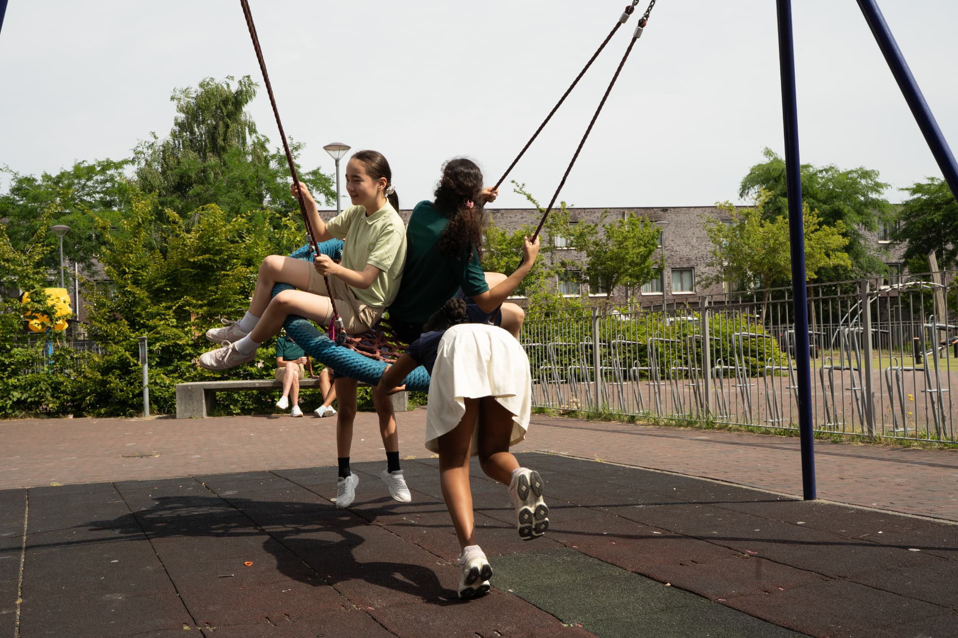 Leerlingen schommelen samen op het schoolplein